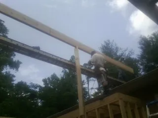 Carpenter setting a ridge beam over a new addition frame — Ice Dam Removal by Roofing Brothers in Youngwood