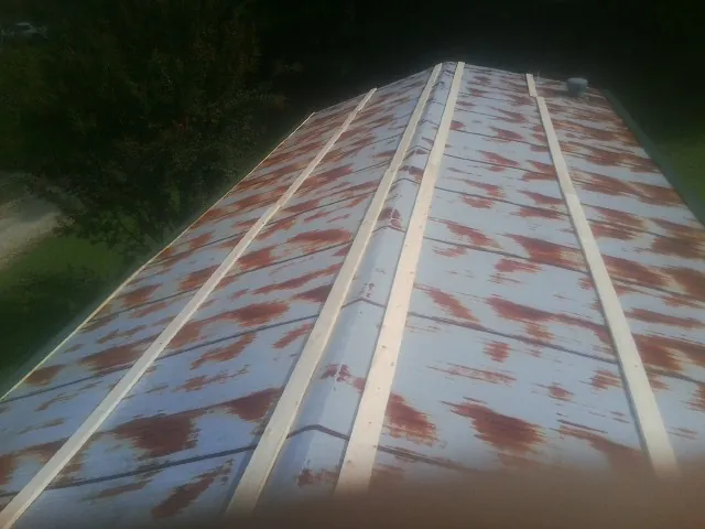 Rusted metal roof panels with new wood purlins before replacement — Storm Damage Roof Repair in Youngwood by Roofing Brothers
