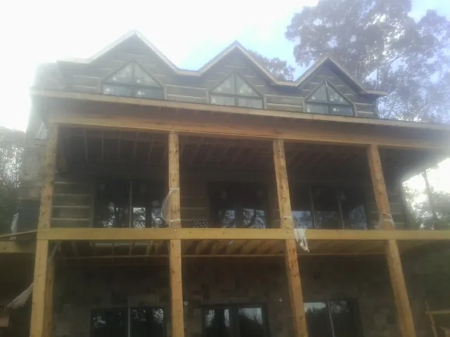 Dormers and porch framing on a large log home under construction — Roof Coating work by our crew in Youngwood