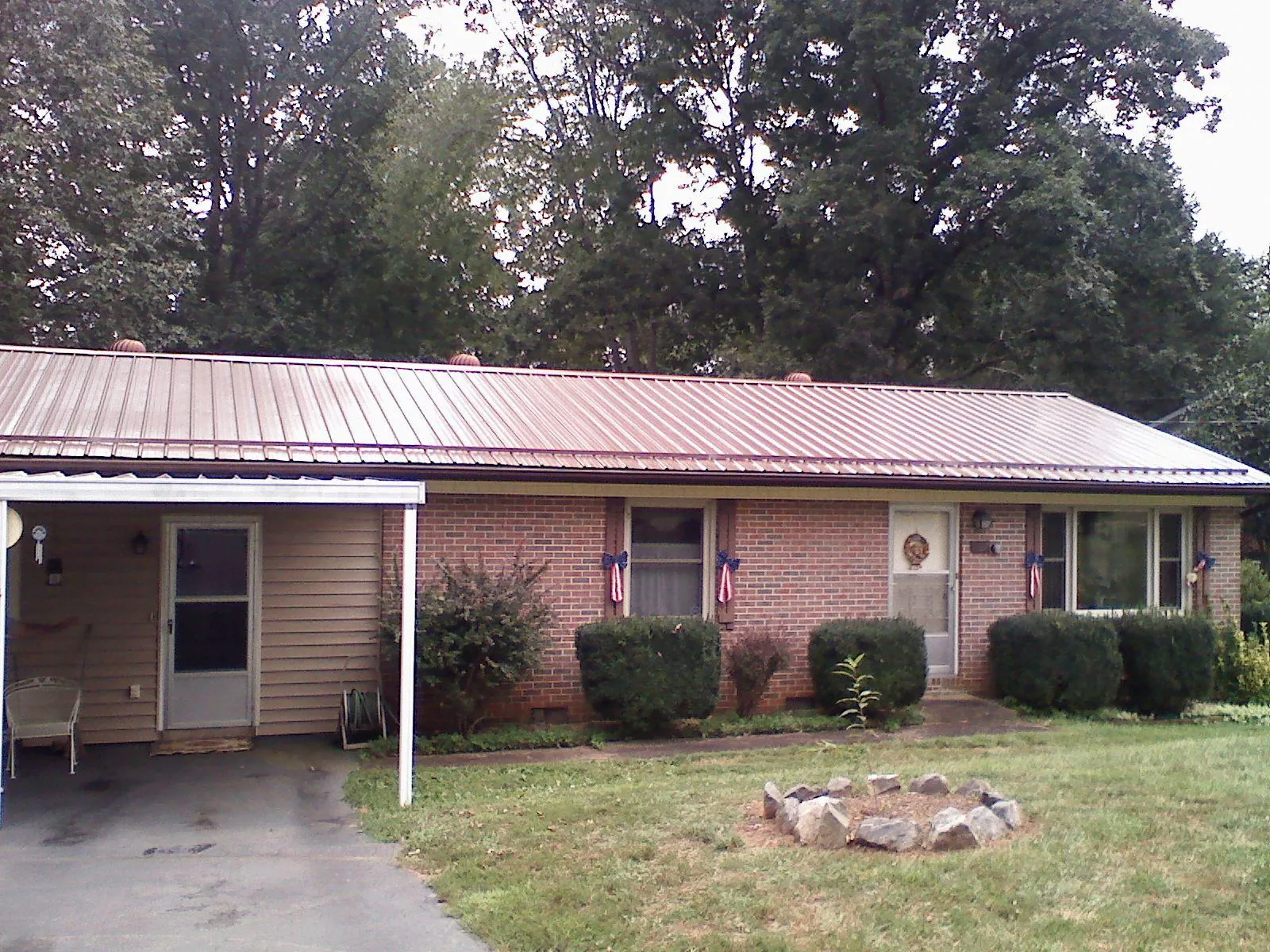Bronze metal roof and carport on a brick ranch home — Roof Repair work by our crew in Youngwood